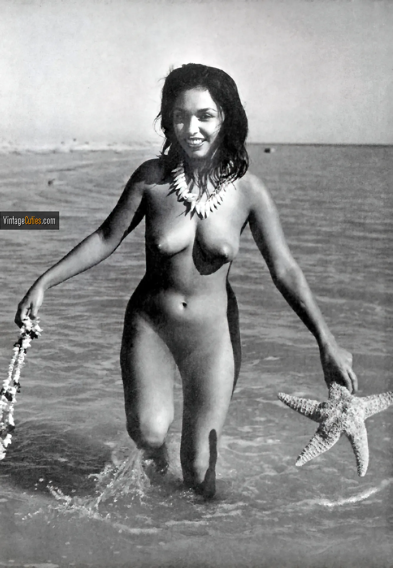 Tanya Muriett posing with her wet tits and a shaved pussy in the water